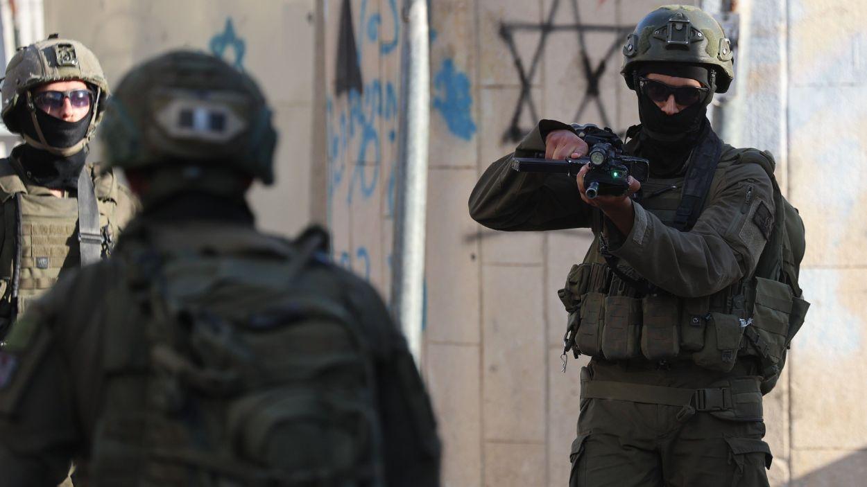 Una família palestina roman dins del seu vehicle després de ser aturada durant una incursió de colons a la Ciutat Vella d’Hebron, mentre les forces israelianes asseguren la zona. EP